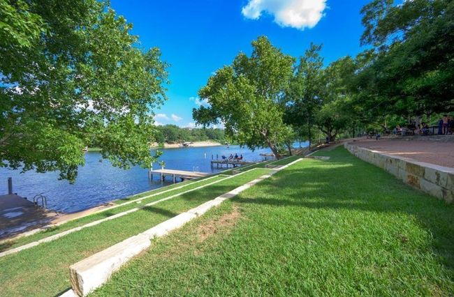 View of grassy yard featuring a water view and a boat dock | Image 34