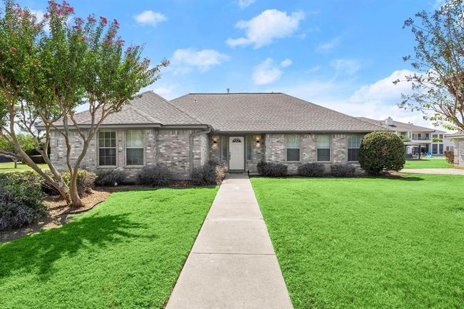 This is a single-story brick house with a well-maintained lawn, mature trees, and a welcoming walkway leading to the front door. It features a large window and an attached garage, set in a pleasant neighborhood with clear skies above. The property has 5 of these homes. Each homes has 3 bedrooms, 2 bathrooms, and a 1 car garage each. | Image 34