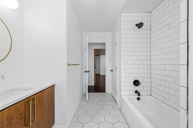 Bathroom with tile patterned floors, vanity, shower / bath combination, and baseboards | Image 23