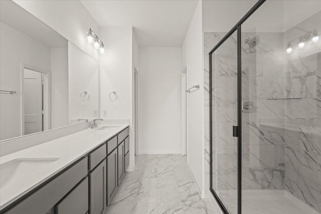 Bathroom featuring marble look tiles, a marble finish shower, and double vanity | Image 8