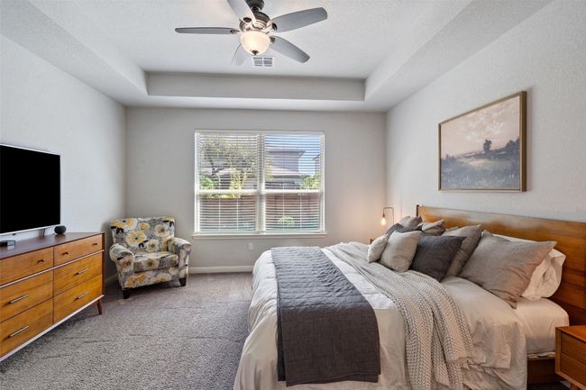 Carpeted bedroom with a tray ceiling and a ceiling fan | Image 27