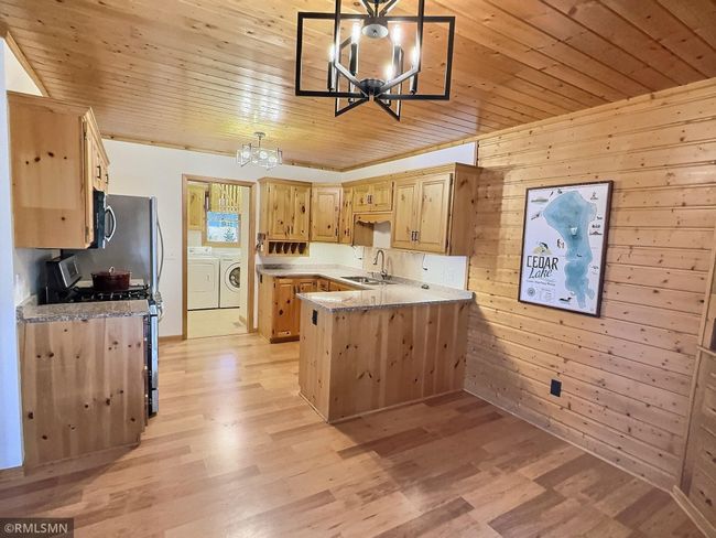 Granite countertops, knotty cedar cabinets and ceiling and newer flooring finish off this main level kitchen. | Image 8