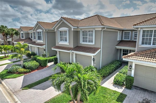 View of front of house with stucco siding, an attached garage, a tiled roof, a residential view, and driveway | Image 6