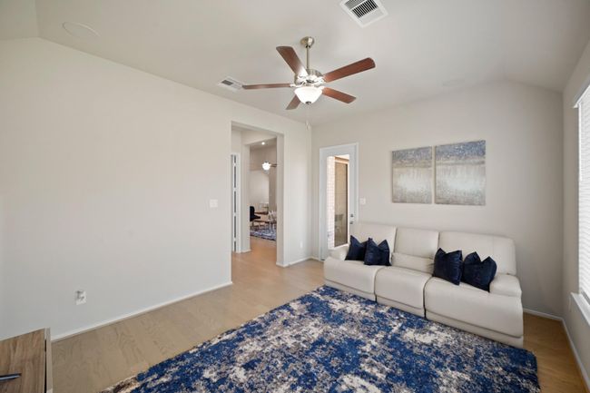 The game room features large windows, high ceiling, ceiling fan, and beautiful floors. | Image 24