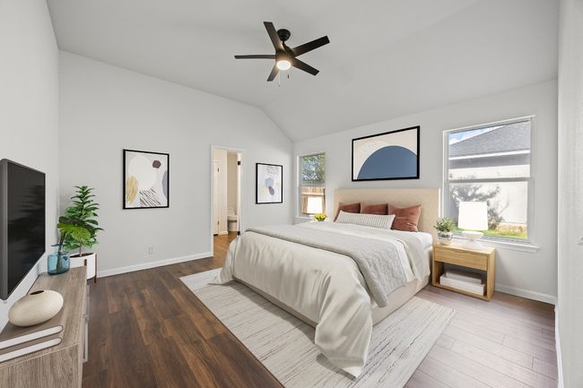 Bedroom featuring vaulted ceiling, wood finished floors, ceiling fan, and ensuite bath | Image 25