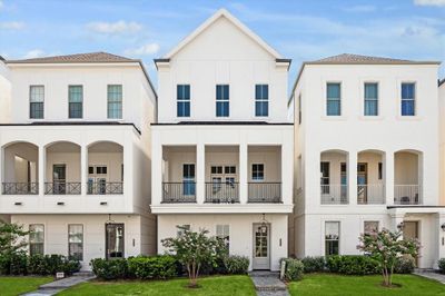 Inside the Guard Gated Houston Community inside the Loop is a 3 story Pelican Builder Built home with an Elevator shaft and outdoor living with green grass in the front of the home | Image 1