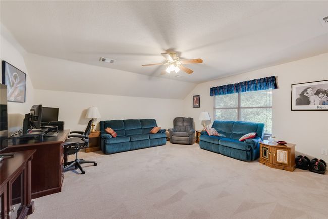 Carpeted living room with a desk, vaulted ceiling, and ceiling fan | Image 32