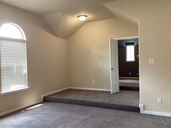 Spare room featuring carpet floors, vaulted ceiling, and baseboards | Image 25