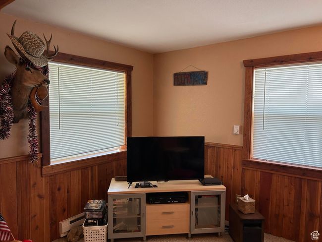 Living room featuring wooden walls, wainscoting, and baseboard heating | Image 18