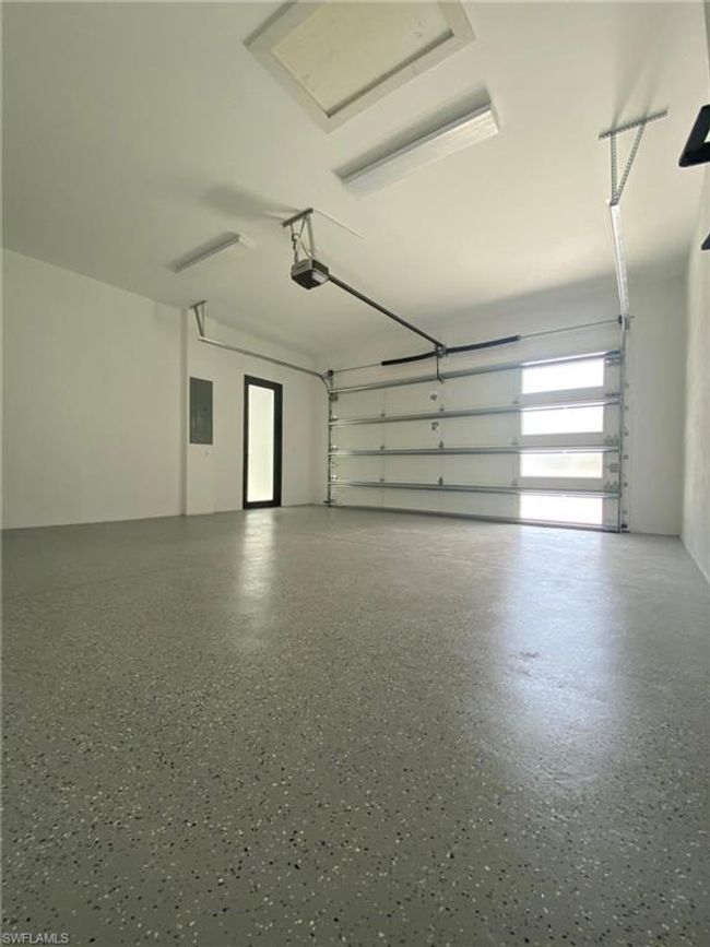 Garage with a garage door opener and Epoxy Flooring | Image 18