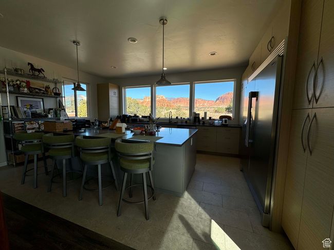 Primary home's kitchen featuring built in refrigerator, a kitchen bar, a healthy amount of sunlight and views plus large island for cooking and entertaining | Image 5