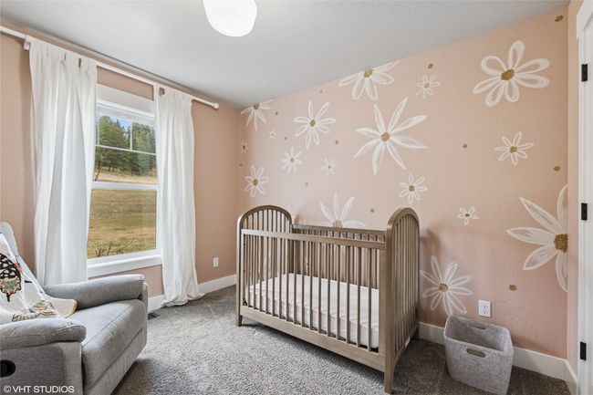Carpeted bedroom featuring wallpapered walls, baseboards, and a nursery area | Image 18