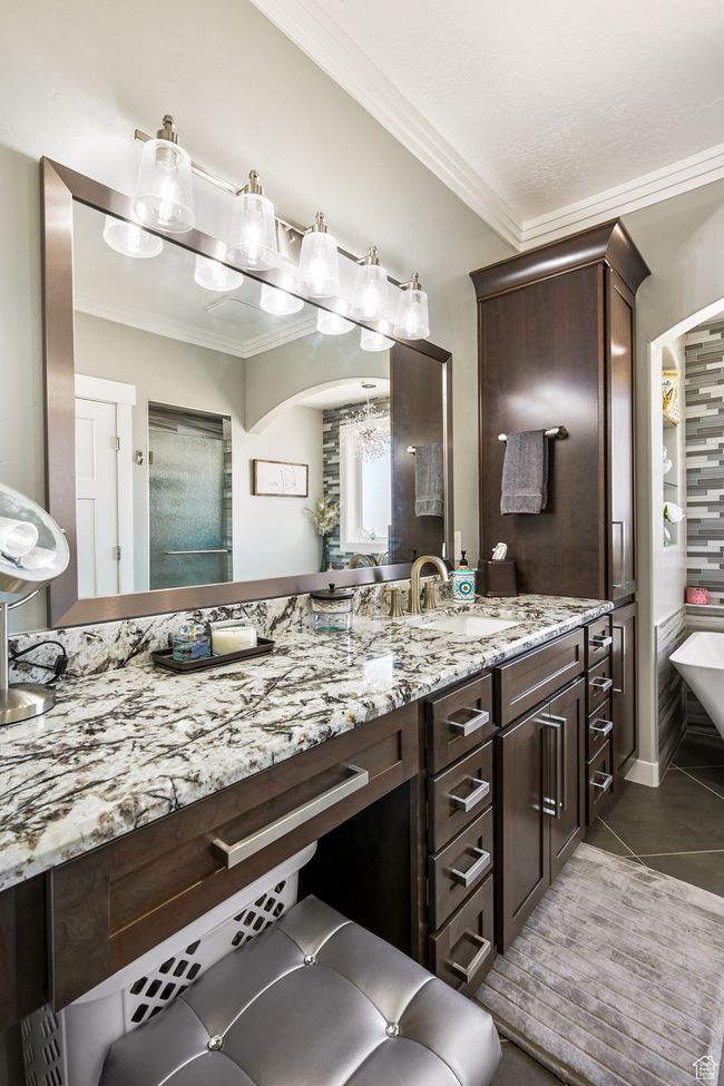 Bathroom featuring ornamental molding, vanity, tile patterned floors, a soaking tub, and a chandelier | Image 44