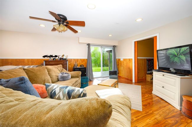 Living room with wainscoting, a ceiling fan, wood finished floors, recessed lighting, and wood walls | Image 23