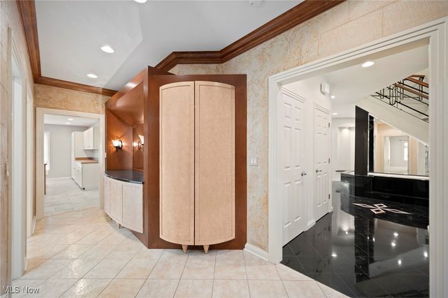 Hall to the pool with ornamental molding, wallpapered walls, stairway, and recessed lighting | Image 32