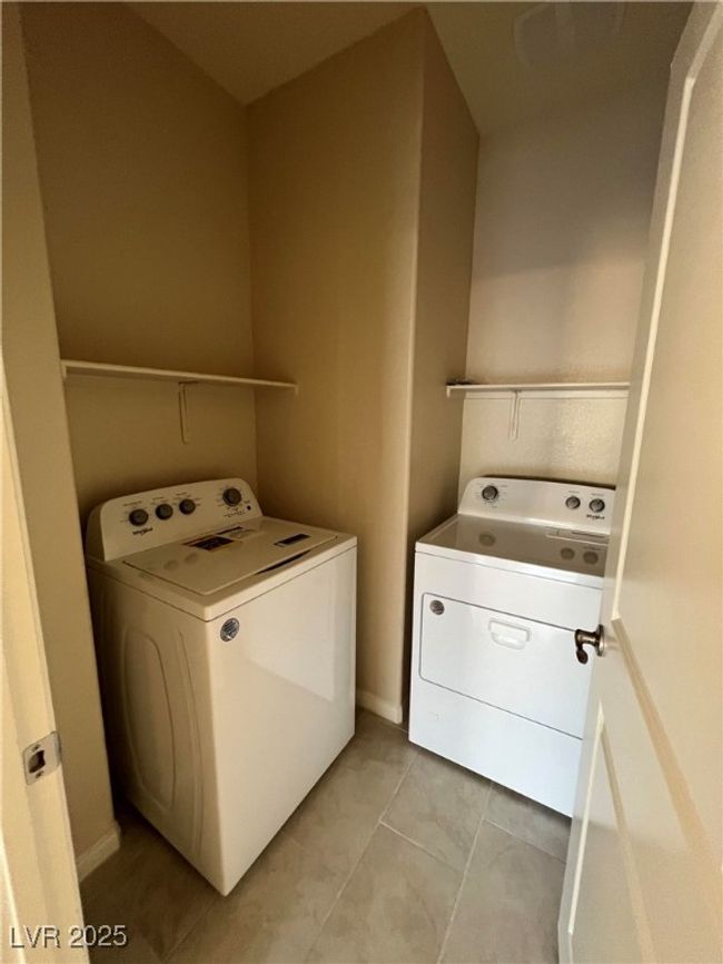 Clothes washing area featuring washing machine and clothes dryer and light tile patterned flooring | Image 25