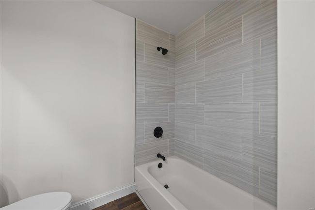 Bathroom featuring baseboards, shower / bathtub combination, and toilet | Image 17
