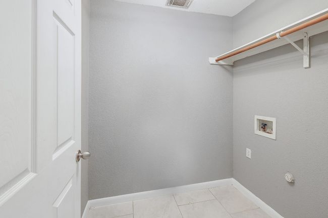Washroom featuring laundry area, light tile patterned floors, visible vents, washer hookup, and baseboards | Image 31