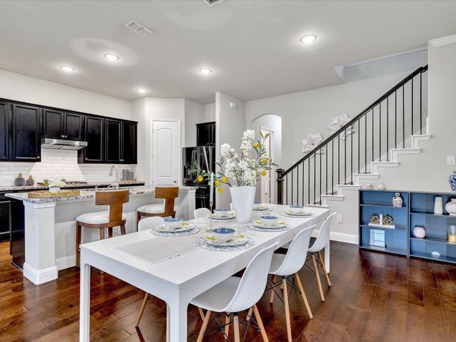 Dining space with dark wood-type flooring, arched walkways, recessed lighting, and stairway | Image 7
