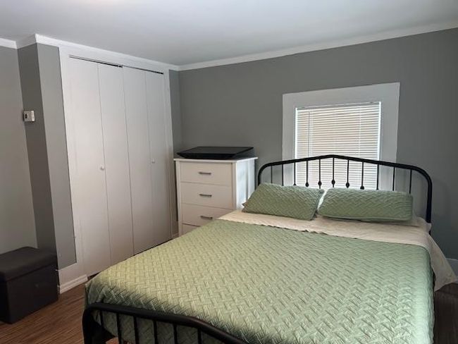 Bedroom with dark hardwood / wood-style flooring, ornamental molding, and a closet | Image 6