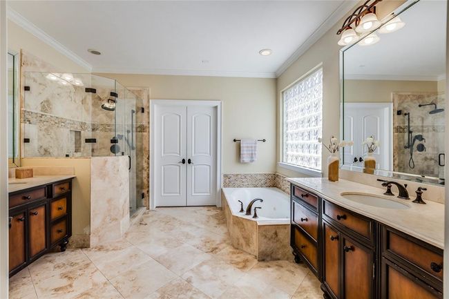 Primary Bathroom with beautiful cabinets with double sinks, oiled rub bronze faucets & light fittings, seamless glass shower, huge closet | Image 24