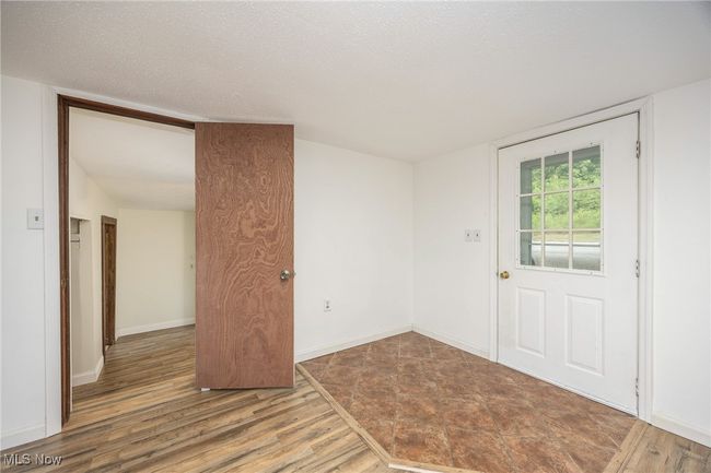 Unfurnished living room with wood finished floors and a textured ceiling | Image 8