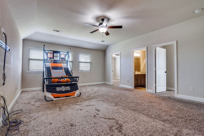 Carpeted bedroom with lofted ceiling, a ceiling fan, a textured ceiling, and ensuite bath | Image 25