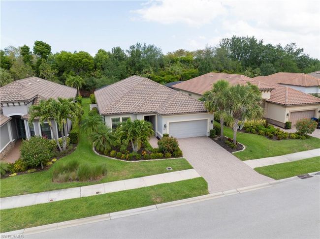 Mediterranean / spanish home featuring a garage, a tiled roof, a front lawn, driveway, and stucco siding | Image 31