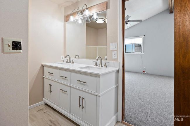 Bathroom featuring double vanity, ceiling fan, and vaulted ceiling | Image 22