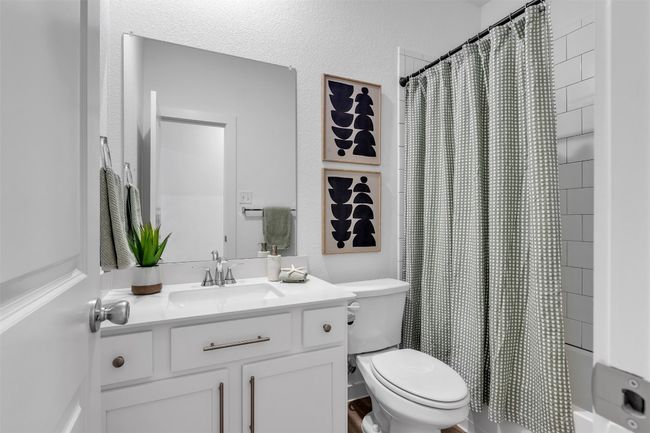 Bathroom featuring vanity, shower / bathtub combination with curtain, and a textured wall | Image 9