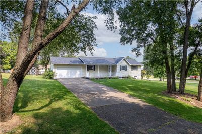 Single story home with a garage, a porch, and a front yard | Image 2