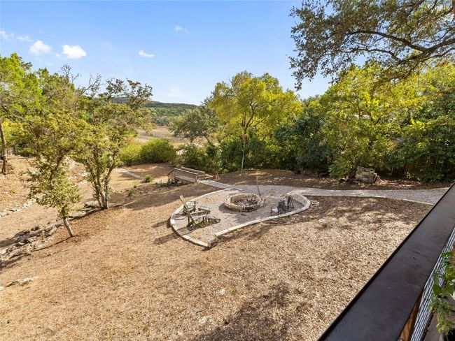 The back yard has a gravel path to the stairs down to the dock and a seating area with firepit. | Image 10