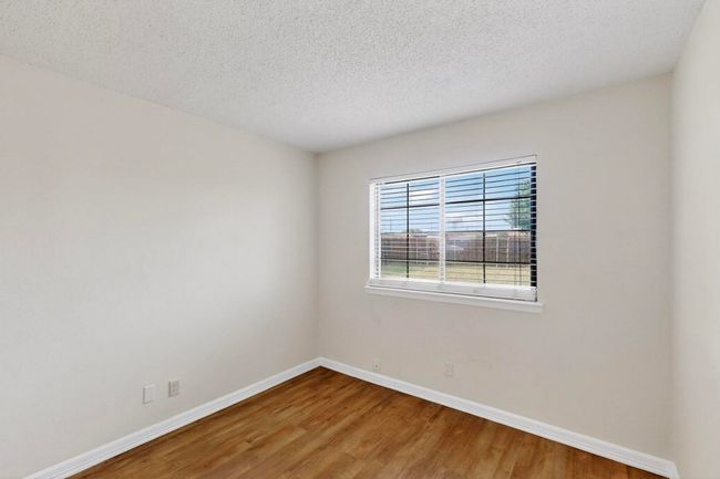 Bedroom featuring wood finished floors and a textured ceiling | Image 24