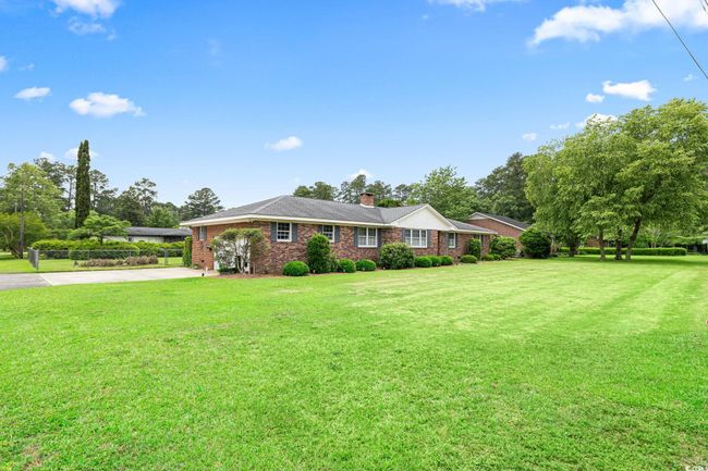 View of front of house with driveway, a front lawn, brick siding, and a chimney | Image 5