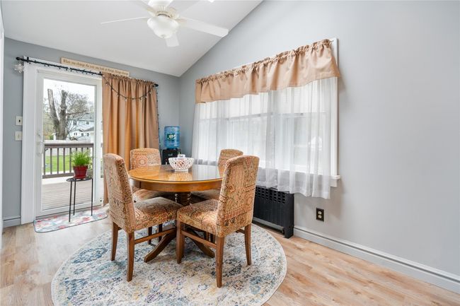 Dining area featuring lofted ceiling, radiator heating unit, wood finished floors, and ceiling fan | Image 11