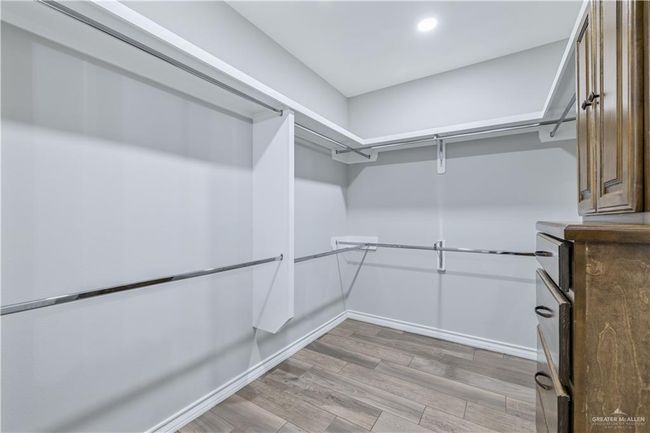 Walk in closet featuring light wood-style floors | Image 6