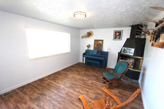 Living area featuring wood finished floors and a textured ceiling | Image 9