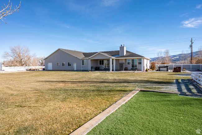 Rear view of property with fence, a patio, a lawn, and a chimney | Image 53