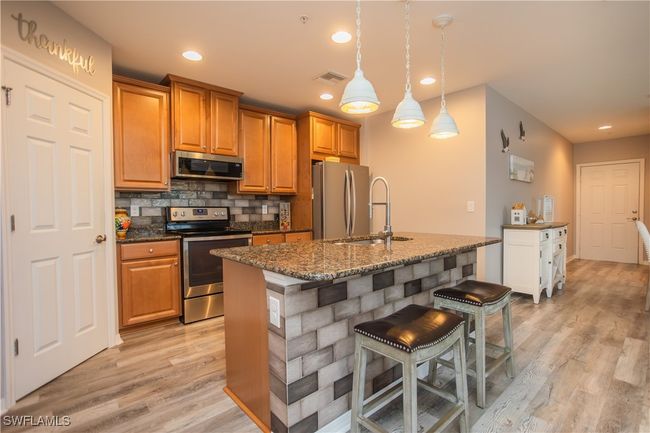 Kitchen with appliances with stainless steel finishes, light wood-style floors, and decorative backsplash | Image 7