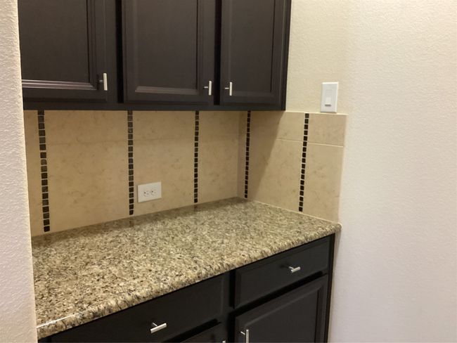 Detailed view of tasteful backsplash and a textured wall | Image 10