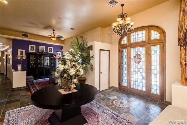 Entrance foyer featuring stone tile flooring, a chandelier, and a ceiling fan | Image 29