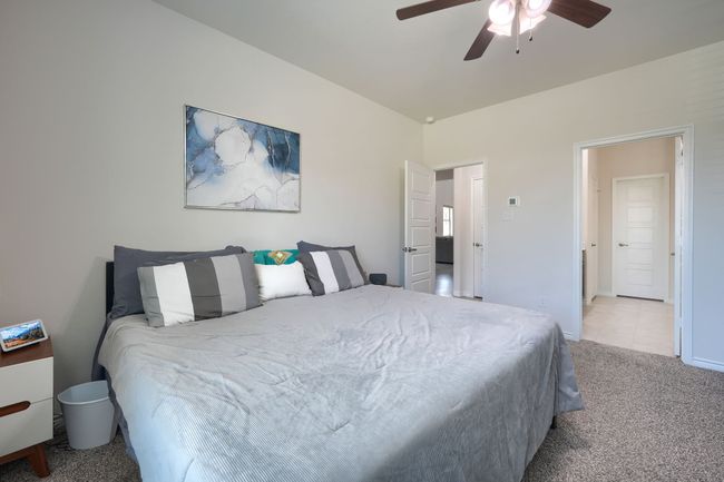 Bedroom featuring light carpet, ceiling fan, and baseboards | Image 19