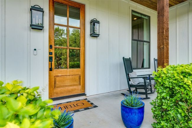 Entrance to property featuring covered porch and board and batten siding | Image 9