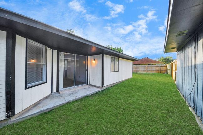 Back patio leading to an oversized backyard. | Image 30