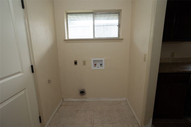 Washroom with full size hookup for an electric dryer, washer hookup, and light tile patterned flooring | Image 18