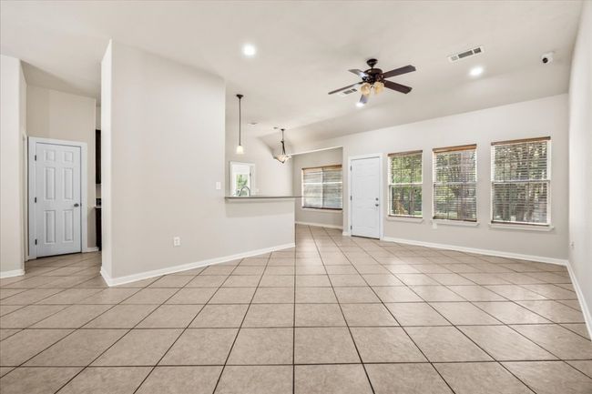 Unfurnished living room with visible vents, ceiling fan, vaulted ceiling, and baseboards | Image 10
