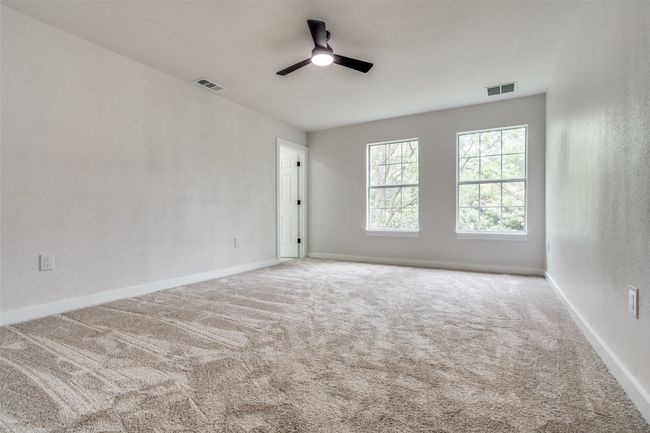Empty room with a ceiling fan and carpet flooring | Image 21