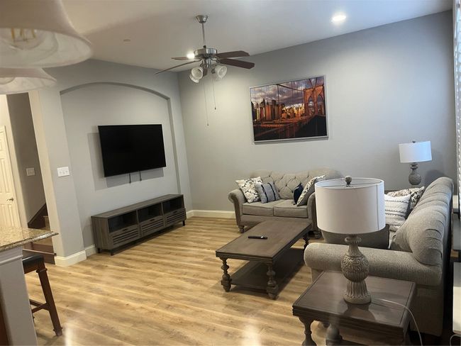Living room with ceiling fan, light wood finished floors, and recessed lighting | Image 7