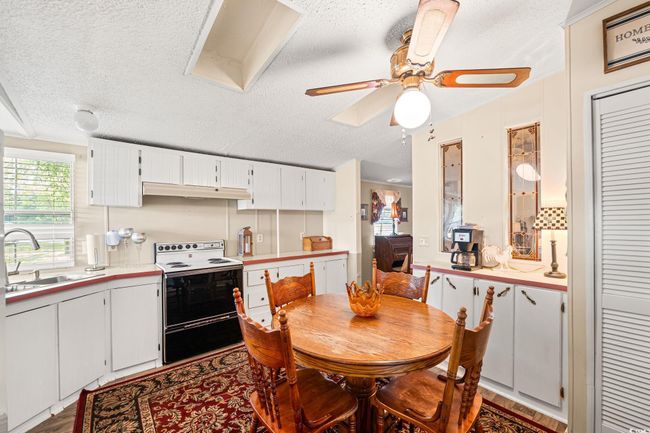 Dining area featuring a textured ceiling, a ceiling fan, and wood finished floors | Image 21