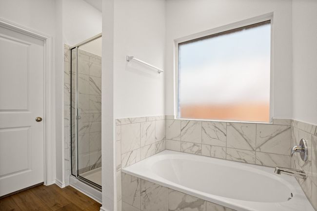 Full bathroom featuring a stall shower, a garden tub, and wood finished floors | Image 16